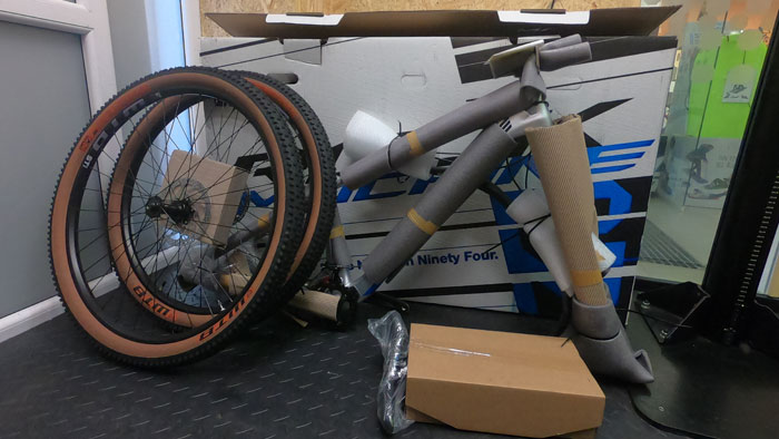 Zabalený nový bicykel Rock Machine a jeho diely vybrané z krabice